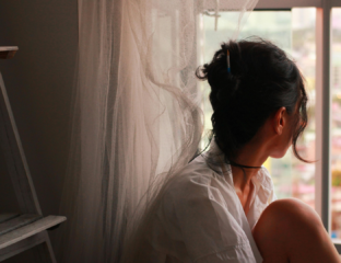 Woman sitting quietly by a sunlit window, taking a calm morning pause to reduce stress and anxiety naturally