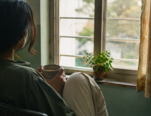 Person sitting quietly by a window holding a cup of chai, reflecting on how to set boundaries without guilt