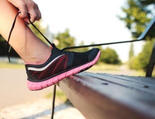 Person lacing up sneakers by the door in the morning, a simple first step toward learning how to start exercising