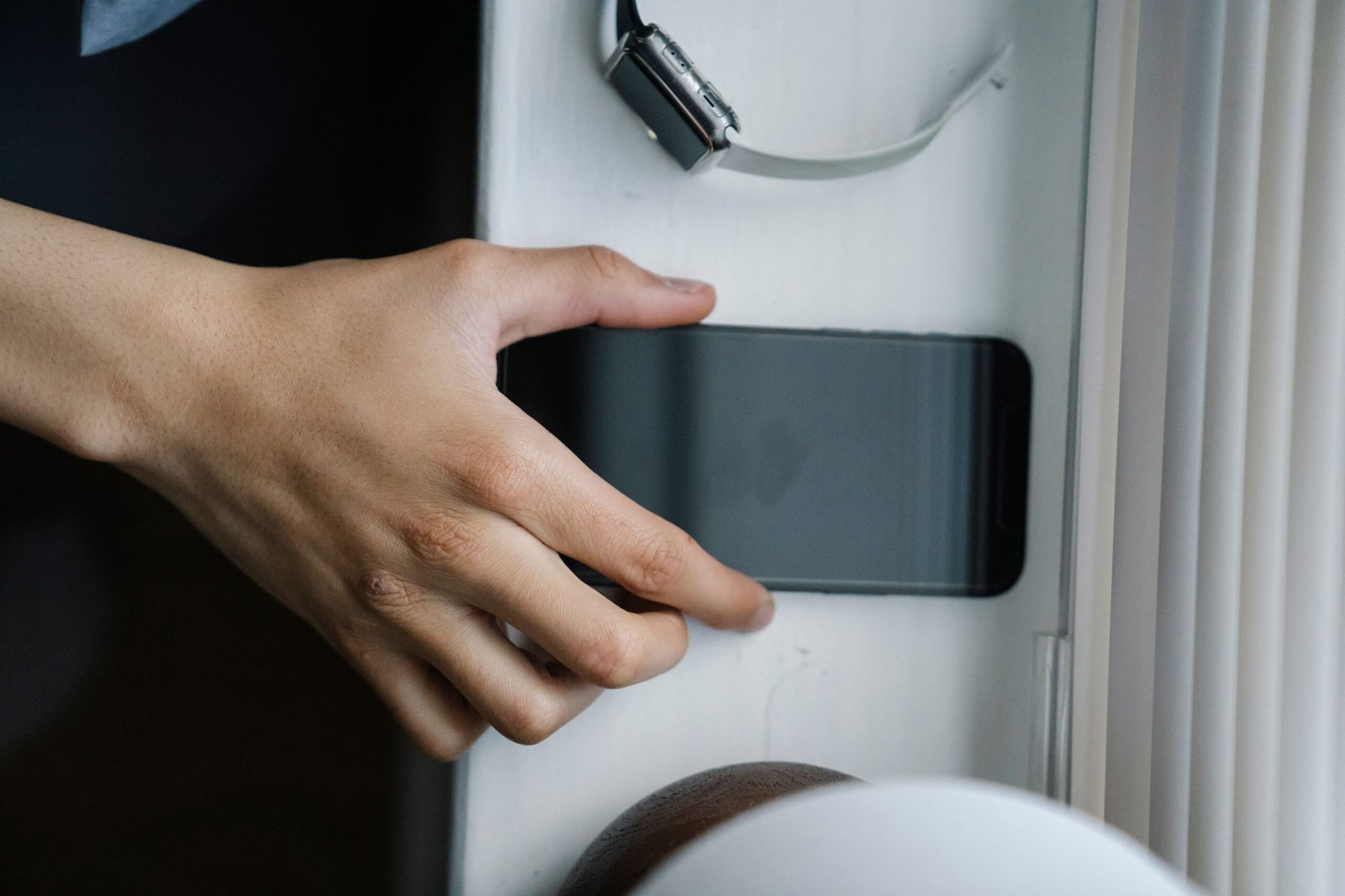 Hand gently placing a phone face-down on a table, a small act of setting boundaries with family and technology