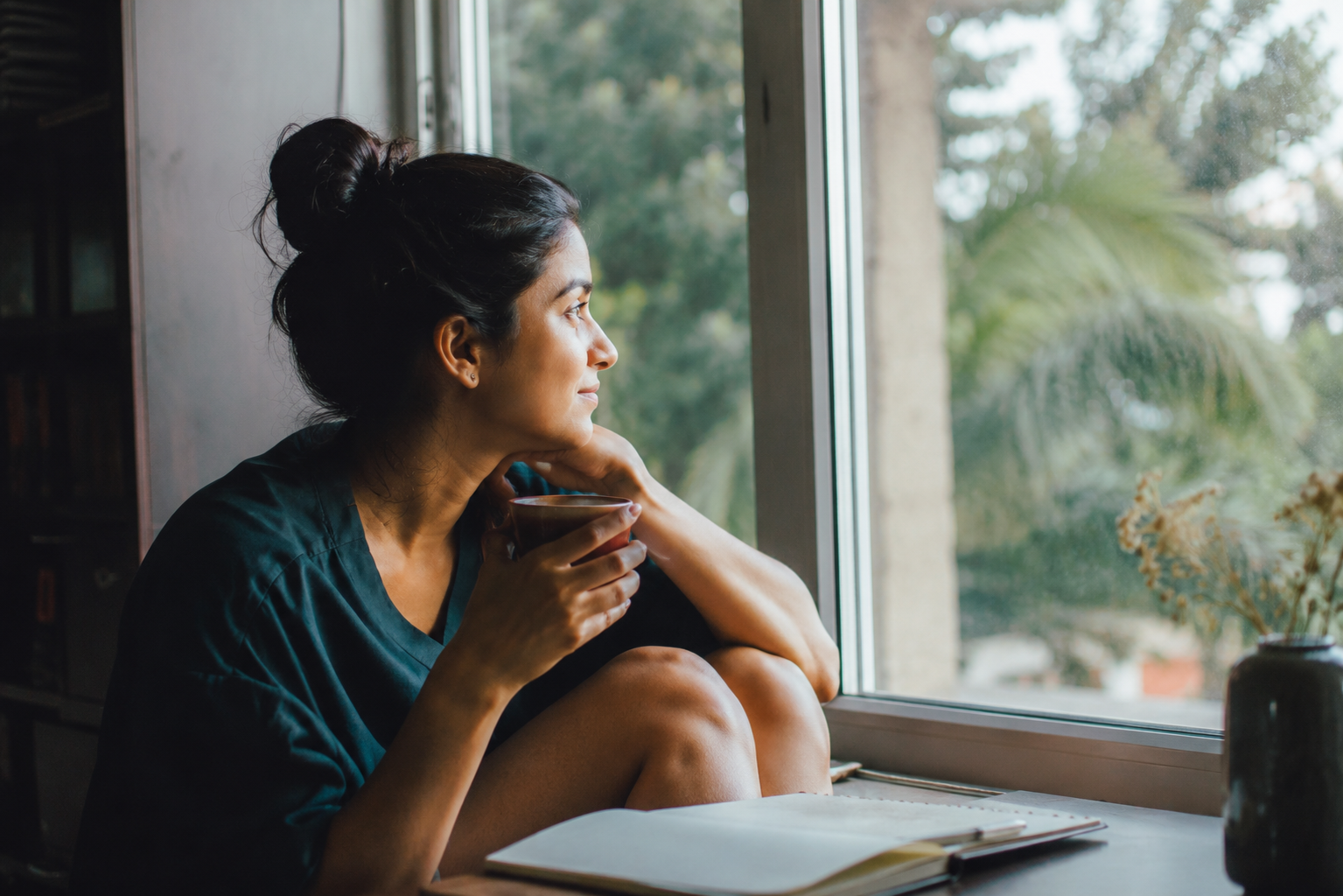 Person journaling by a window, reflecting on whether they are job hugging out of fear