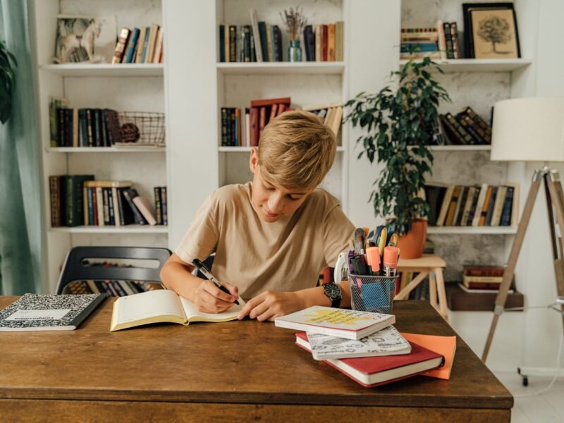 A student using a tablet alongside a printed workbook, reflecting a balanced approach to digital learning