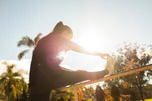 A person stretching calmly by a window as part of a simple morning routine